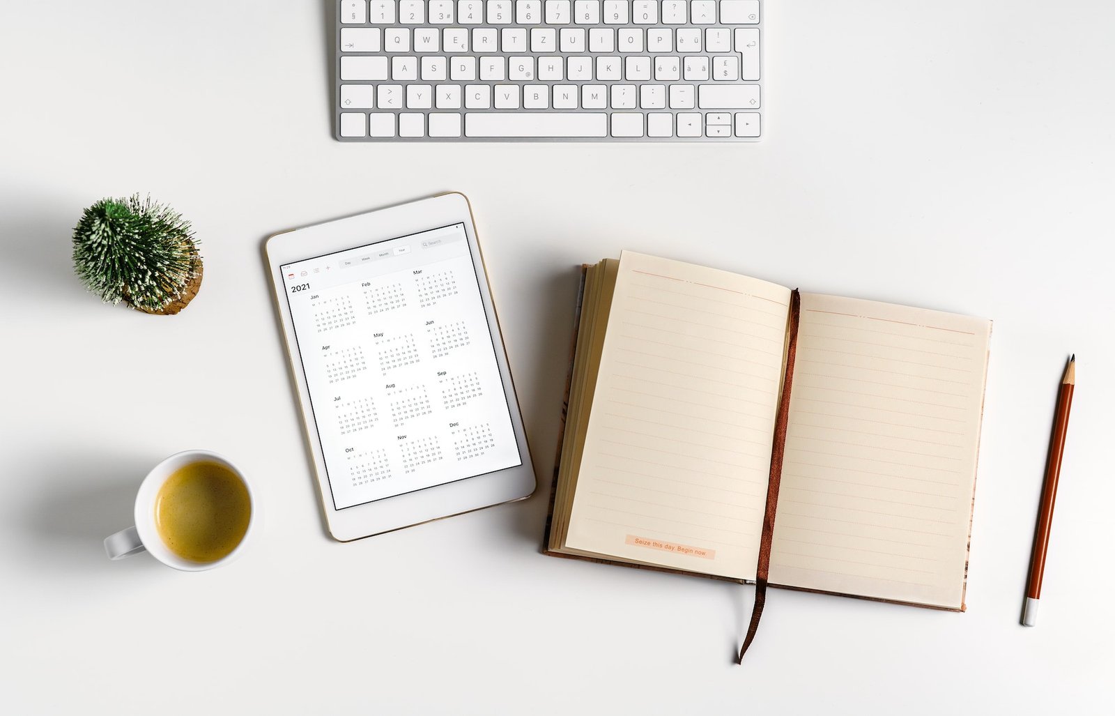 Minimal calendar flat lay. Digital tablet with open calendar app and empty notebook